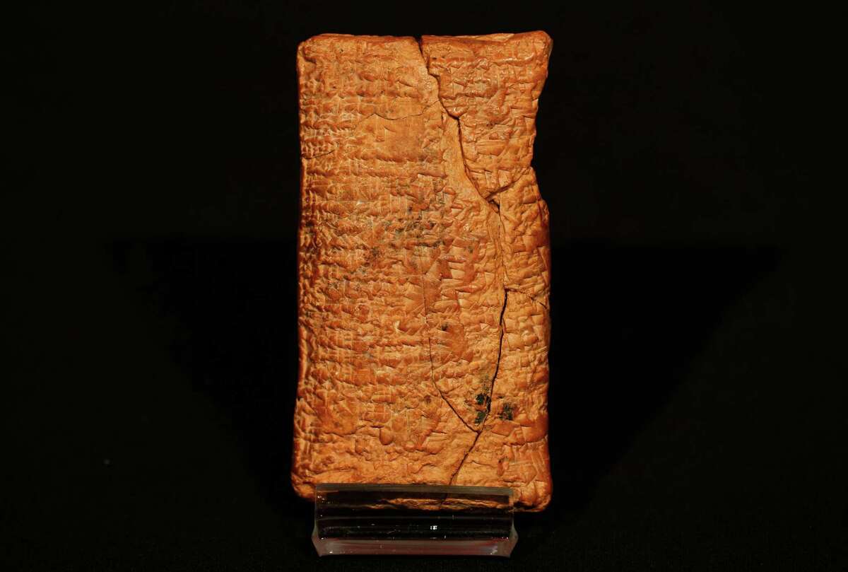 The 4000 year old clay tablet containing the story of the Ark and the flood stands on display at the British Museum in London during the launch of the book 'The Ark Before Noah' by Irving Finkel, curator in charge of cuneiform clay tablets at the British Museum, Friday, Jan. 24, 2014. The book tells how he decoded the story of the Flood and offers a new understanding of the Old Testament's central narratives and how the flood story entered into it. (AP Photo/Sang Tan)