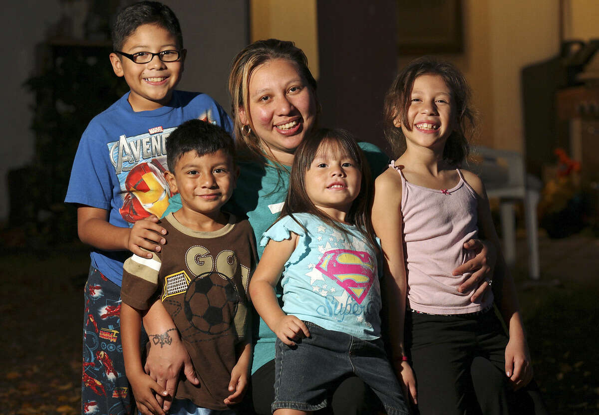Portrait of Irma Aguilar (center) and her children Jacob Martinez, 10, (from left), Izaiah Aguilar, 5, Rihanna Aguilar, 4, and Monique Aguilar, 8, Thursday Nov. 21, 2013 at their home.