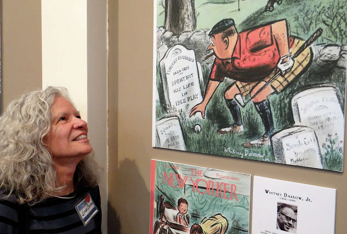Linda Darrow, daughter of artist Whitney Darrow Jr., gazing at New Yorker magazine cover art the Westporter created at the opening Sunday of Westport Historical Society's exhibits on the town's ties to the magazine over the years.