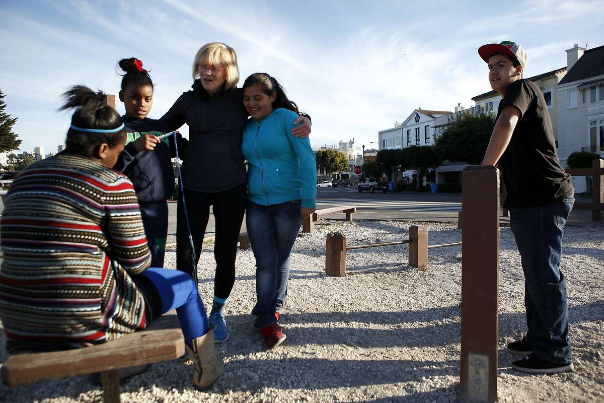 Marina Middle School Assistant Principle Ginny Daws talks with students (L-R) Tyler Tukes, Tre'jor Barber, Sofia Sanchez and Ivan Ortega as they take a break at an exercise park during their run in the Marina District of San Francisco, CA, Tuesday, January 21, 2014. In a move that has seen a decrease of suspensions, Assistant Principle Ginny Daws has started running with some students after class, an activity and approach that is part of a big shift in how the district deals with defiant kids.