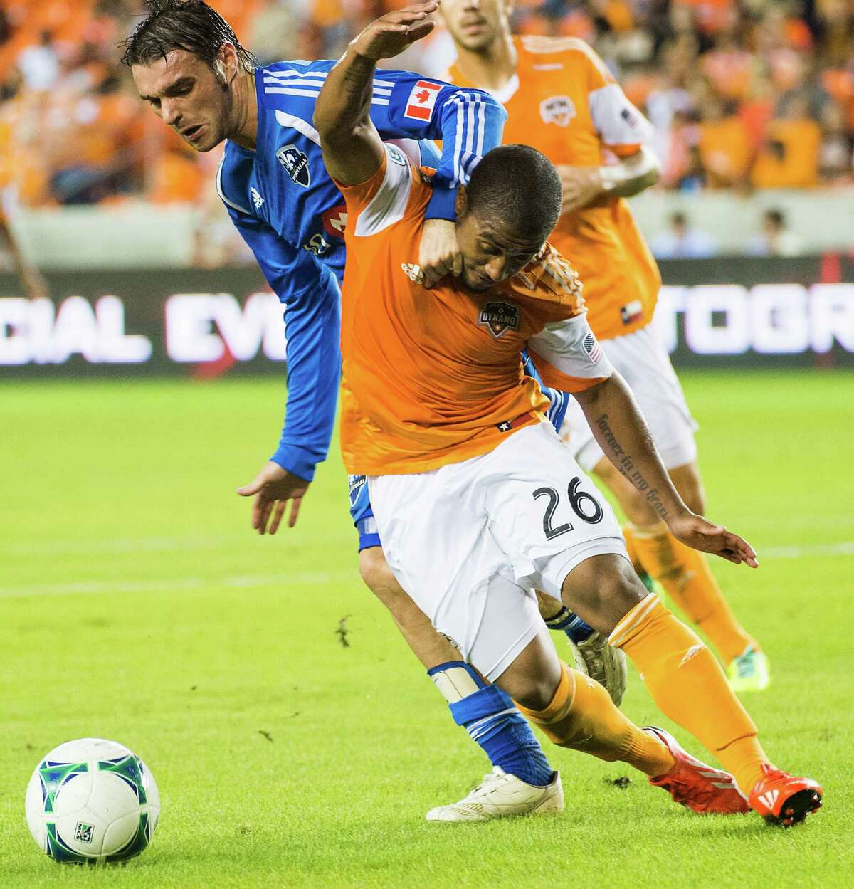 Houston Dynamo midfielder Corey Ashe (26) fights for the ball against Montreal Impact midfielder Andrea Pisanu (31) during the first half of a MLS playoff soccer match on Thursday, Oct. 31, 2013, at BBVA Compass Stadium in Houston. ( Smiley N. Pool / Houston Chronicle )