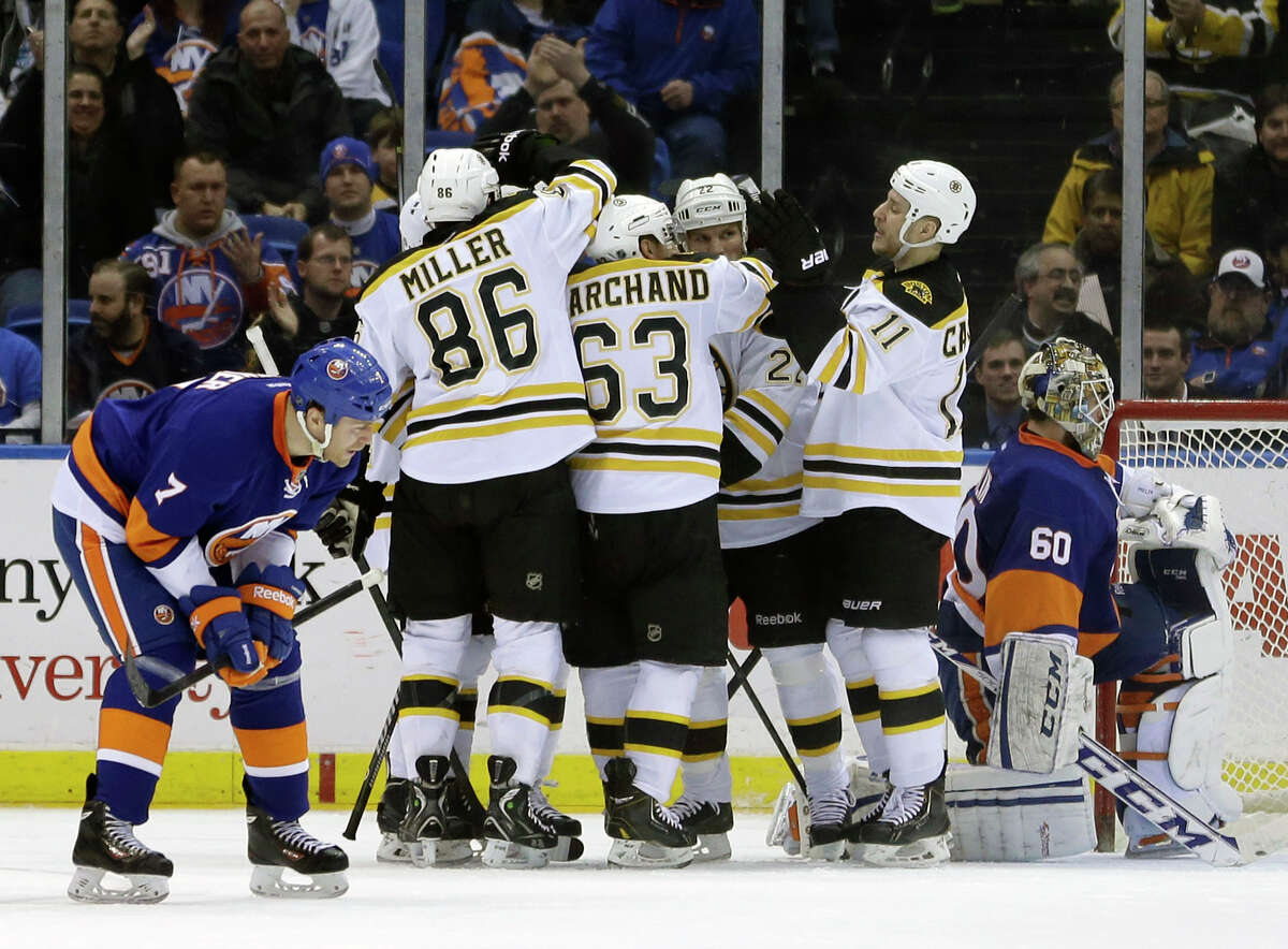 The Boston Bruins celebrate a goal by Reilly Smith while New York Islanders goalie Kevin Poulin, right, and Matt Carkner, left, react during the second period of the NHL hockey game, Monday, Jan. 27, 2014, in Uniondale, New York. (AP Photo/Seth Wenig) ORG XMIT: NYSW109
