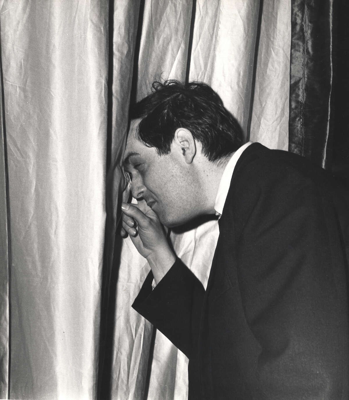 American film director Stanley Kubrick peeks through a curtain on the set of his film 'Dr. Strangelove, Or How I Learned to Stop Worrying and Love the Bomb' (1964) England, early 1963.