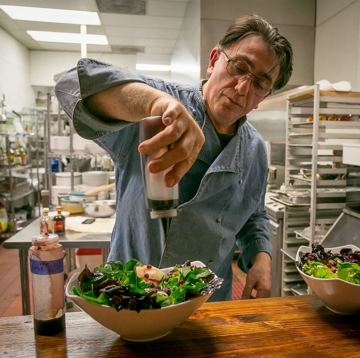 Chef/owner Michael Mazaferri dresses the Gem salad at Aly's on Main in Redwood City, Calif., on January 21st, 2014.