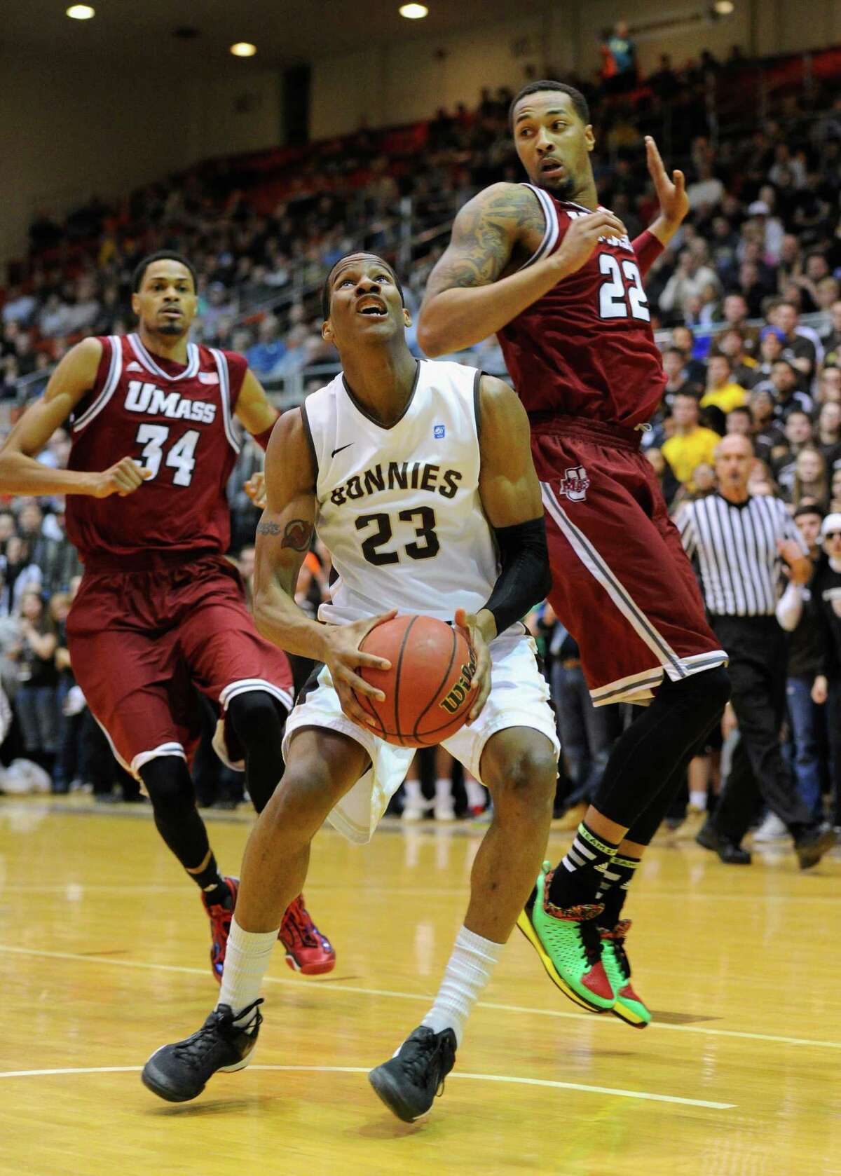 OLEAN, NY - JANUARY 29: Andell Cumberbatch #23 of the St. Bonaventure Bonnies drives to the basket against the defense of Sampson Carter #22 of the Massachusetts Minutemen during the first half at the Reilly Center on January 29, 2014 in Olean, New York. St. Bonaventure defeated Massachusetts 78-65. (Photo by Rich Barnes/Getty Images) ORG XMIT: 461948565