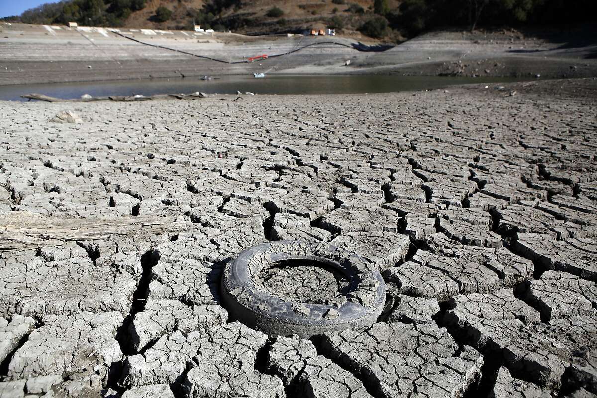 A discarded tire is seen stuck in the exposed lake bed of the Almaden Reservoir which is experiencing extremely low water levels due to the ongoing drought, in San Jose.