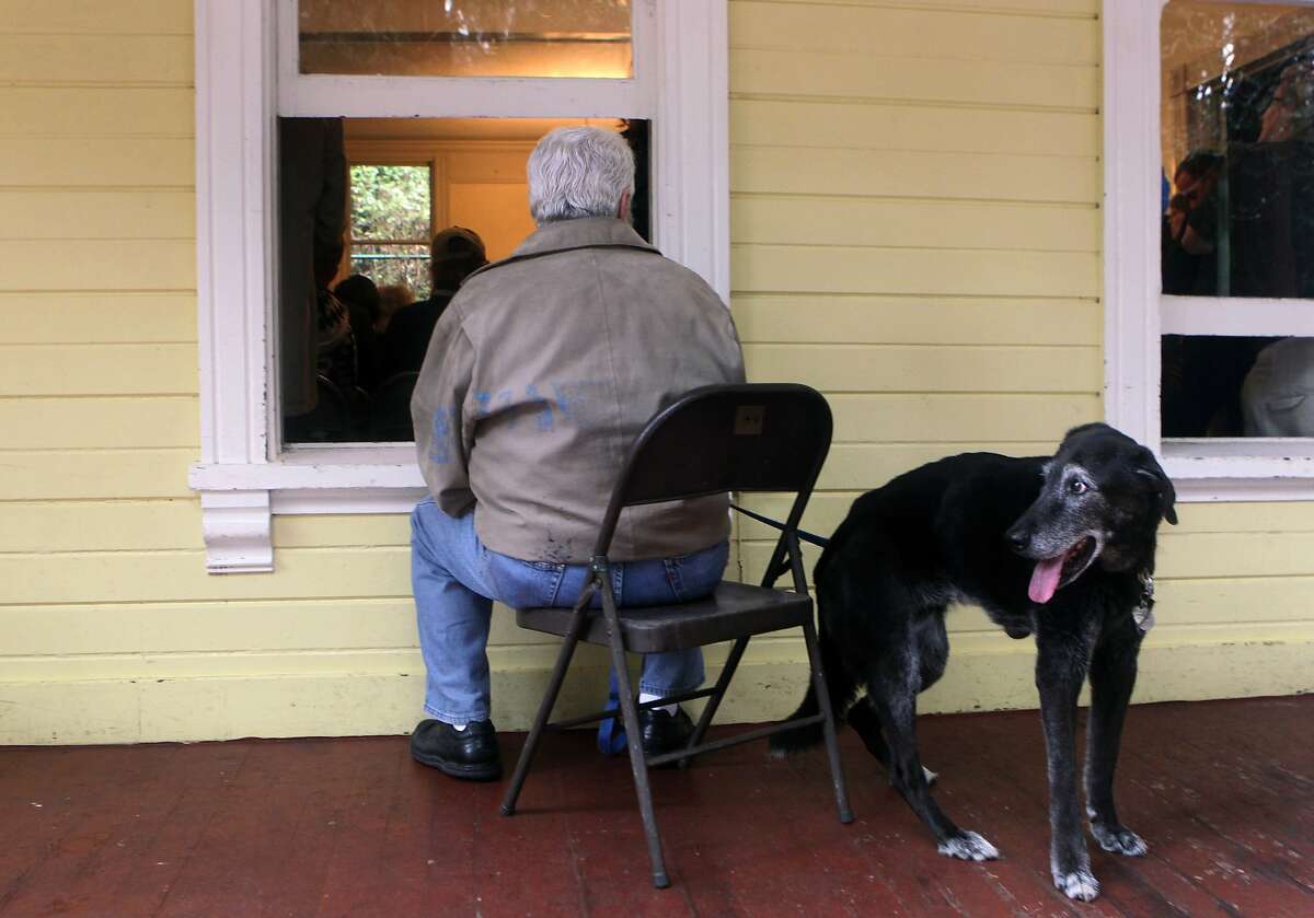 David Hurowitz and his dog Guinness listen from the porch of the Trocadero Clubhouse where a standing-room-only crowd attended a public meeting at Stern Grove in San Francisco, Calif. on Thursday, Jan. 30, 2014, to discuss the GGNRA's proposed rules and restrictions on off-leash dogs.