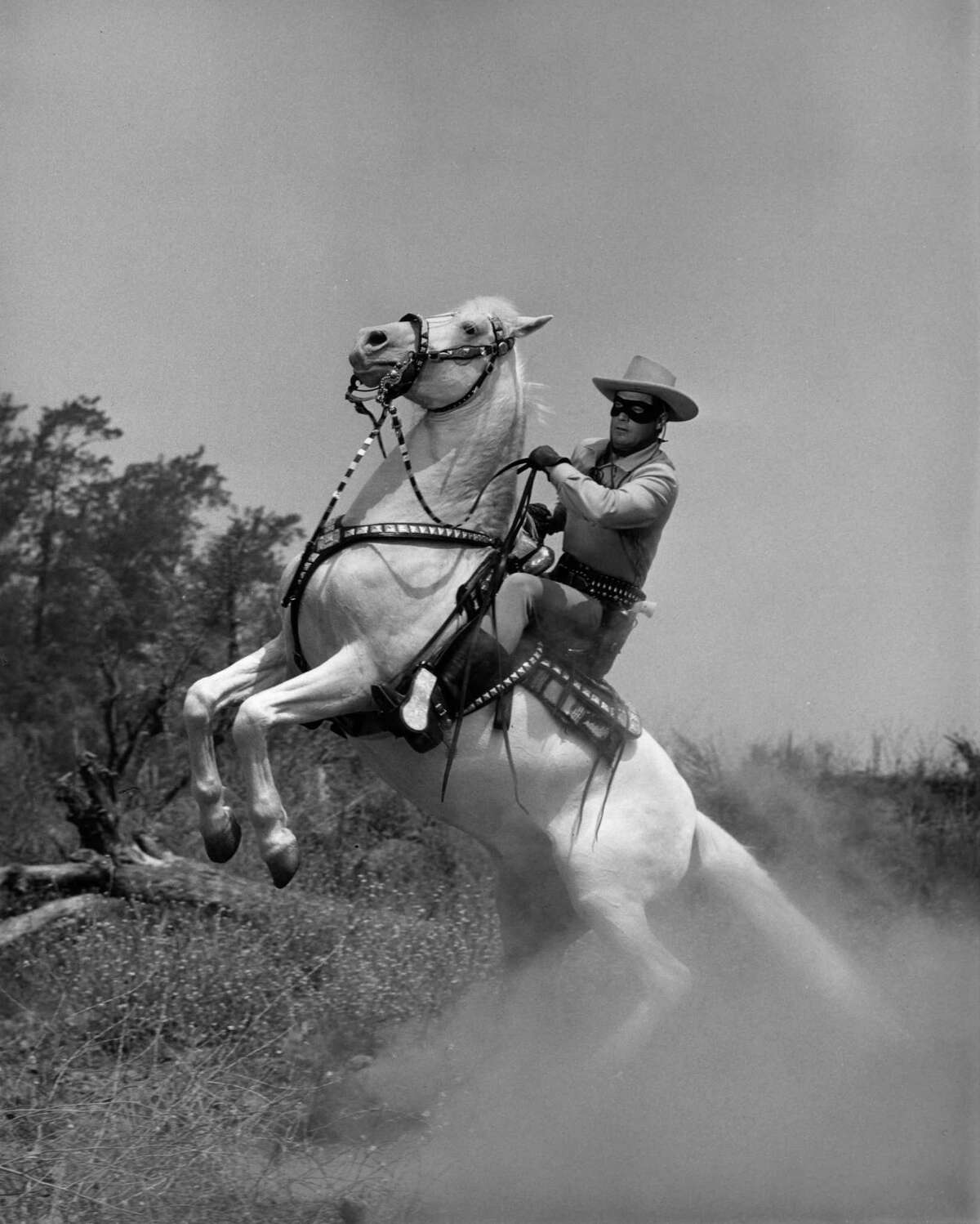 circa 1955: American actor Clayton Moore, in masked costume as 'The Lone Ranger,' rears back on his horse, Silver, in a still from the American television series, 'The Lone Ranger'.