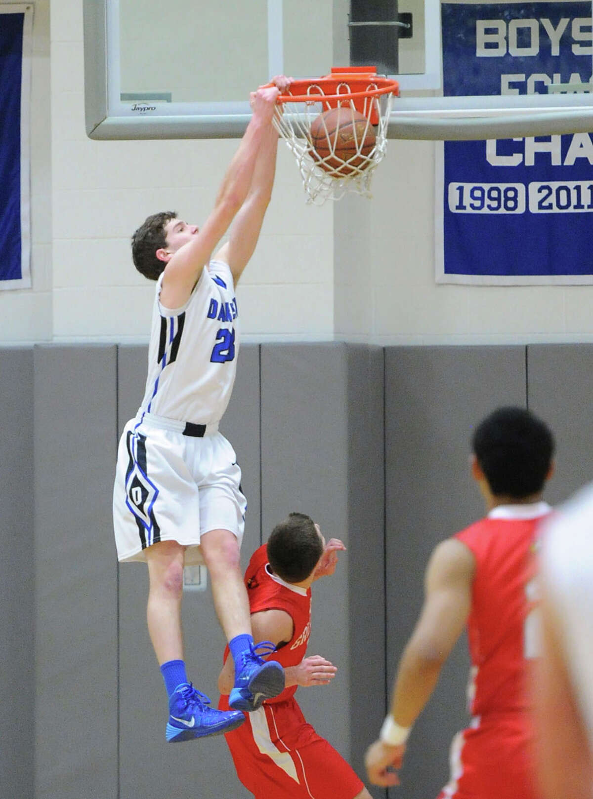 At left, Hudson Hamill (#23) of Darien dunks the ball on Tommy Povinelli of Greenwich during the boys high school basketball game between Darien High School and Greenwich High School at Darien, Friday night, Jan. 31, 2014.