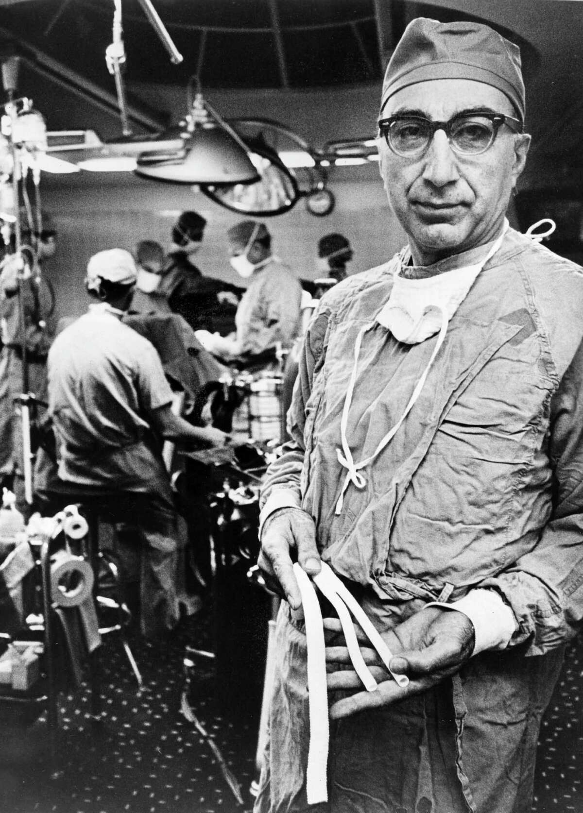 The gift of graft Baylor College of Medicine is credited with inventing the Dacron graft, which usually replaces or repairs blood vessels. Houston's Dr. Michael Ellis DeBakey was the first U.S. surgeon to remove an aneurysm in the aorta near the stomach.Here, Dr. DeBakey holds arterial grafts in 1966, fabricated from knitted Dacron tubing which have proven to be, in this gifted surgeon's hands, a lifesaving device for hundreds of his patients. 