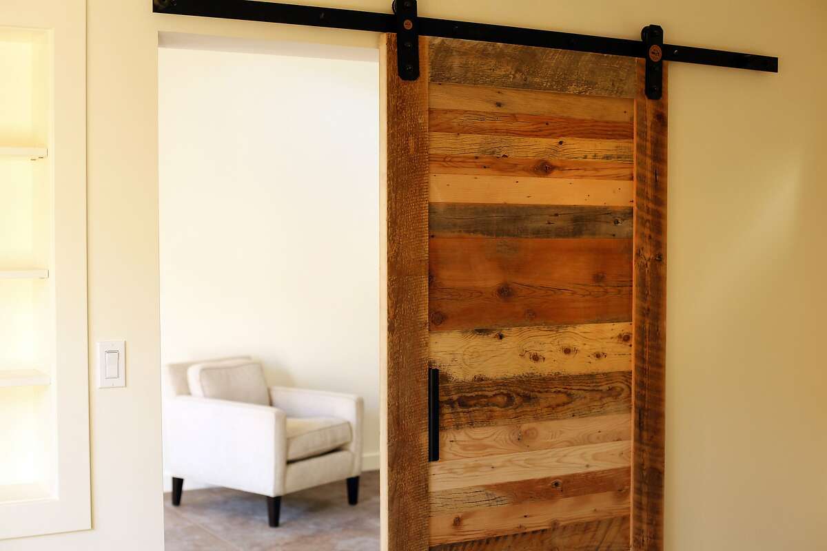 A barn door closes off a bedroom from a living room in the cottage Bruce and Nancy Chamberlain built in their backyard for extra space in Berkeley, Calif., on Saturday, February 1, 2014.