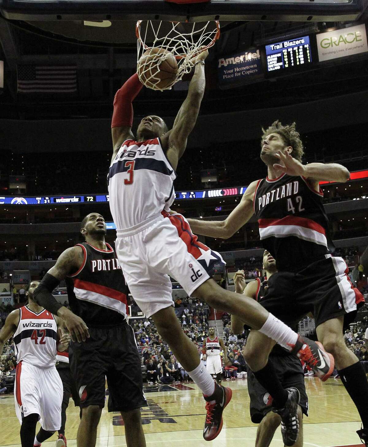 Wizards guard Bradley Beal dunks in front of the Trail Blazers' Robin Lopez (right) and LaMarcus Aldridge. Beal finished with 13 points and six assists.