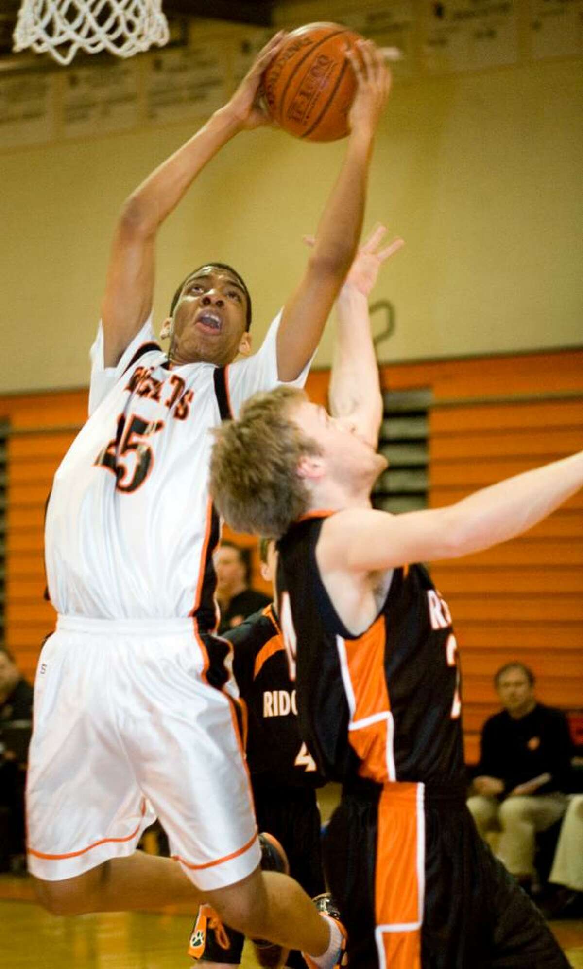Stamford High School's #25 Terrance Dimitri, left, takes a shot on basket as he's defended by Ridgefield High School's #24 Ryan Curnal during a boys basketball game in Stamford on Feb. 5, 2010.