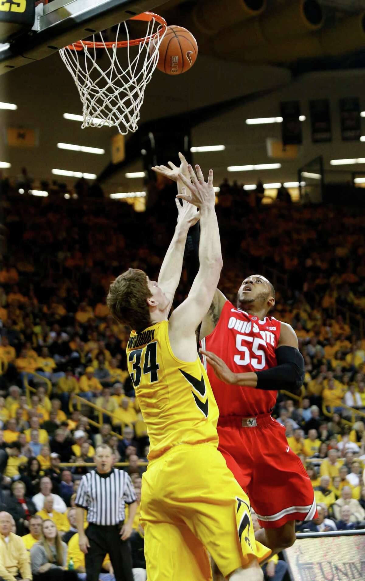 Iowa center Adam Woodbury (34) defends on a shot by Ohio State center Trey McDonald (55) during the first half of an NCAA college basketball game Tuesday, Feb. 4, 2014, in Iowa City, Iowa. (AP Photo/Cliff Jette) ORG XMIT: IAJC108