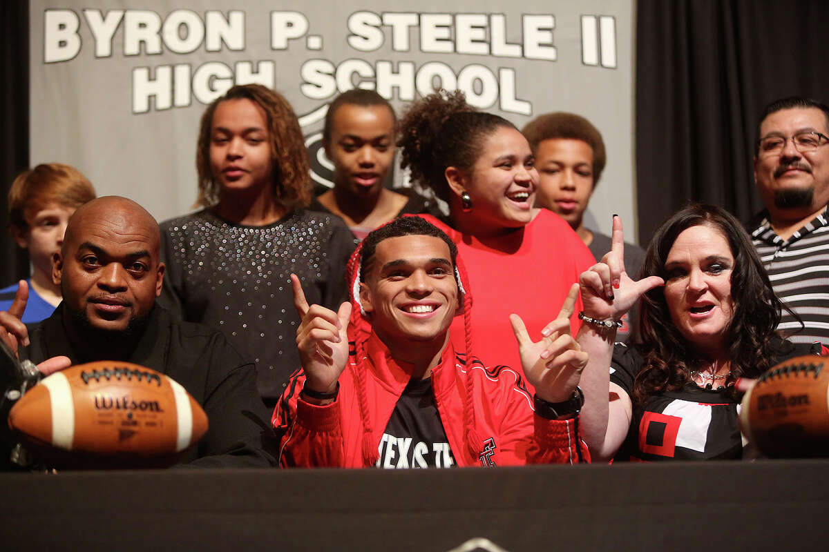 Justin Stockton celebrates after signing to play football for Texas Tech with his family including his father, Eric Harris, left, and mother, Melissa Stockton, right, on National Signing Day at Steele High School in Cibolo on Wednesday, Feb. 5, 2014.