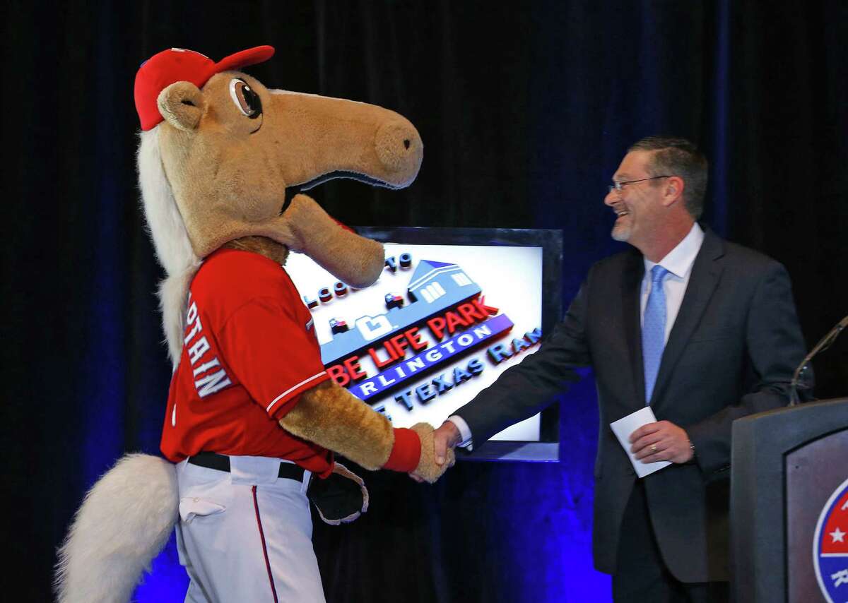 Bill Leavell, president of Globe Life Insurance, shakes hands with Rangers mascot Captain in announcing a naming-rights deal for the ballpark.