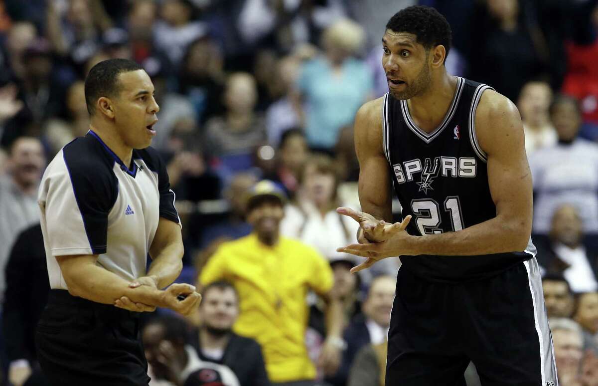 Referee Curtis Blair, left,calls a sixth foul on San Antonio Spurs forward Tim Duncan (21) in the second overtime of an NBA basketball game against the Washington Wizards, Wednesday, Feb. 5, 2014, in Washington. Duncan had 31 points and the Spurs won 125-118 in double overtime. (AP Photo/Alex Brandon)