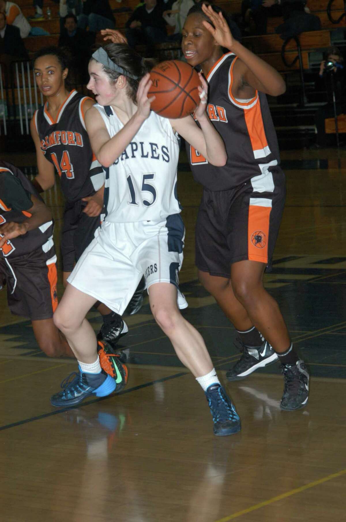Staples' Madeline Schemel, center, holds the ball during girls basketball game game Tuesday.
