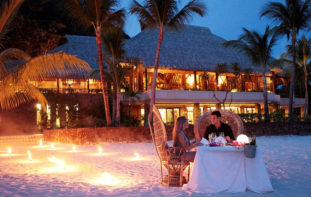 A romantic dinner for two on the beach sets the scene for romance at the Hilton Bora Bora Nui in French Polynesia.