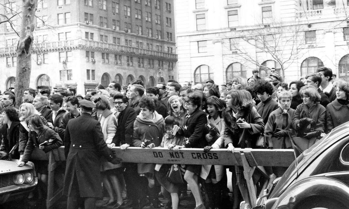 Police enforce the barricades outside New York's Plaza Hotel as fans push forward in hopes of a view of The Beatles after their arrival for an American tour on February 7, 1964.