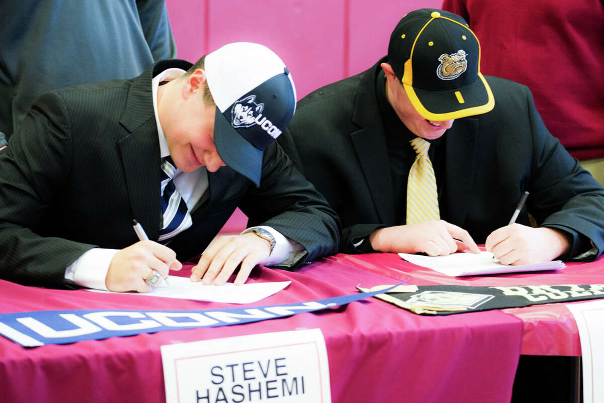 Steve Hashemi, left, and Peter Mestre signing their letters of intent. Hashemi will play football at UConn, Mestre at Byrant College.