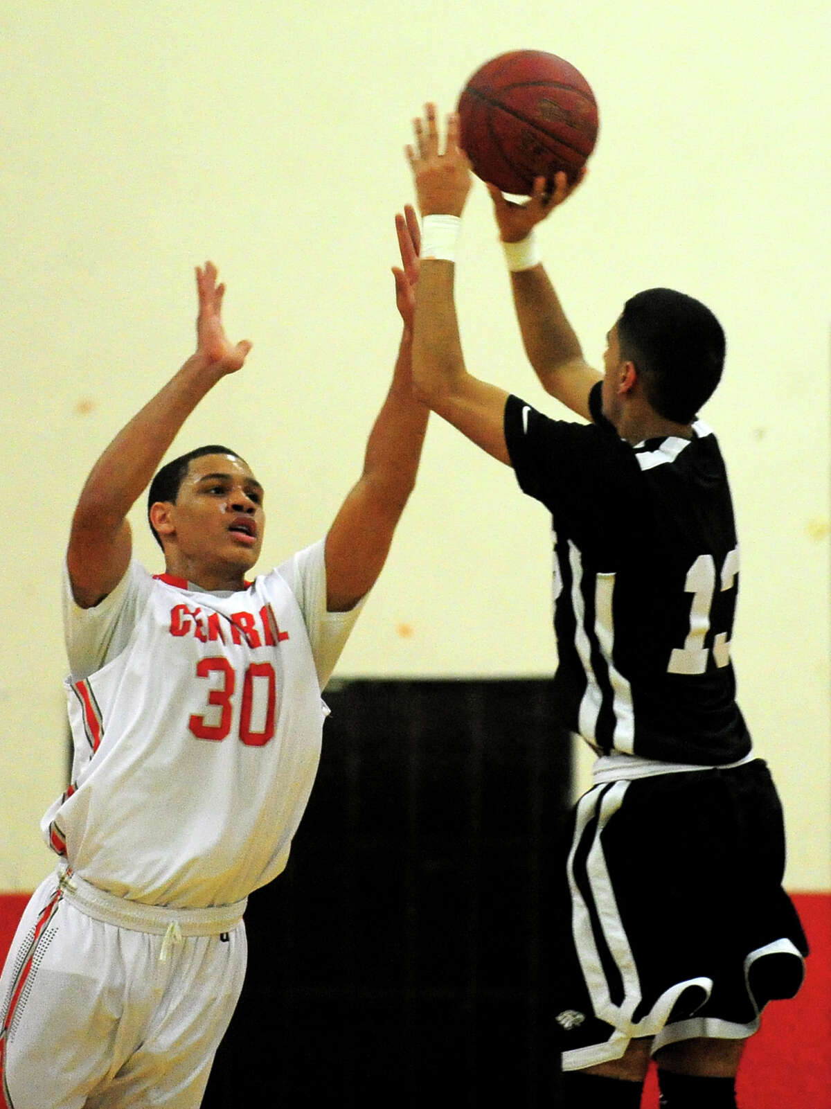 Central's Marcus Blackwell looks to block a shot by Trumbull's Rashard Rodriquez, during boys basketball action against Trumbull in Bridgeport, Conn. on Friday February 7, 2014.