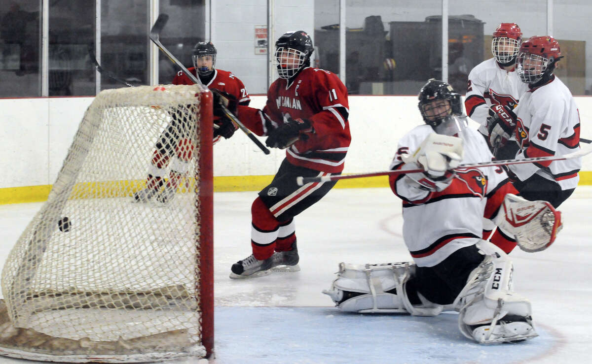 New Canaan's John O'Rourke puts the puck in the net as Greenwich hosts New Canaan High School in a boys hockey game at Dorothy Hamill Rink in Greenwich, Conn., Feb. 8, 2014.