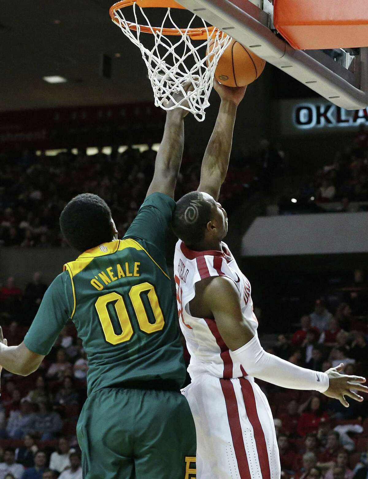 Oklahoma guard Buddy Hield (right) puts up a layup in front of Baylor forward Royce O'Neale. The Sooners also had success from 3-point range, making 14 shots from beyond the arc.