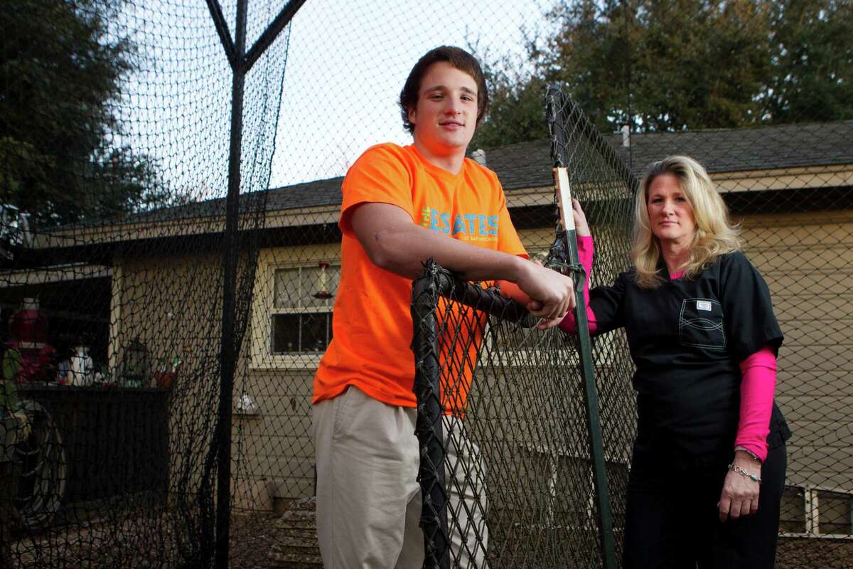 Grady Hefley, 17, poses for a portrait with his mother, Johanna, inside his batting cage in his back yard Wednesday, Feb. 5, 2014, in West University. Hefley suffered a number of concussions when he was 13.