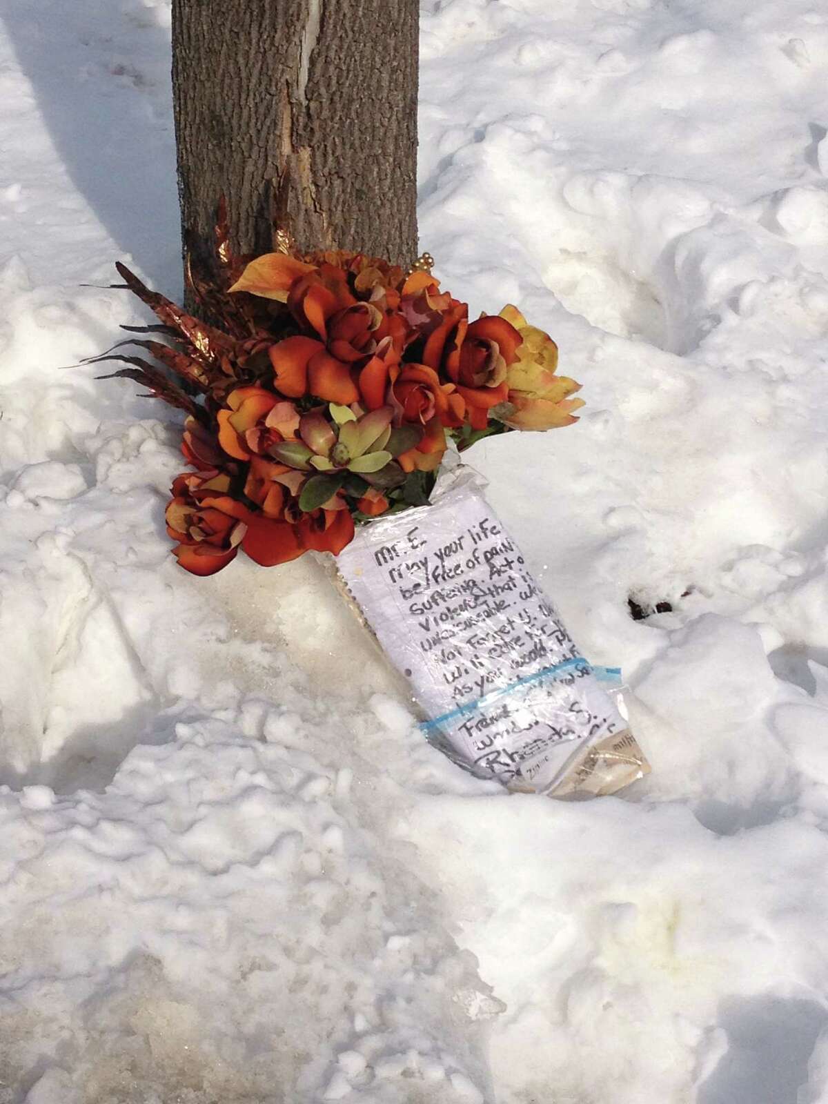 Flowers and a note set outside the Woodside Drive home of Richard Englander, who police say was killed Thursday by his recently hired home health aide. (Bryan Fitzgerald/Times Union)