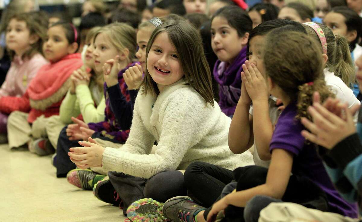 Skyla Durand and classmates enjoy a performance at Harvard Elementary. A booming housing market has changed the demographics at the Heights school.