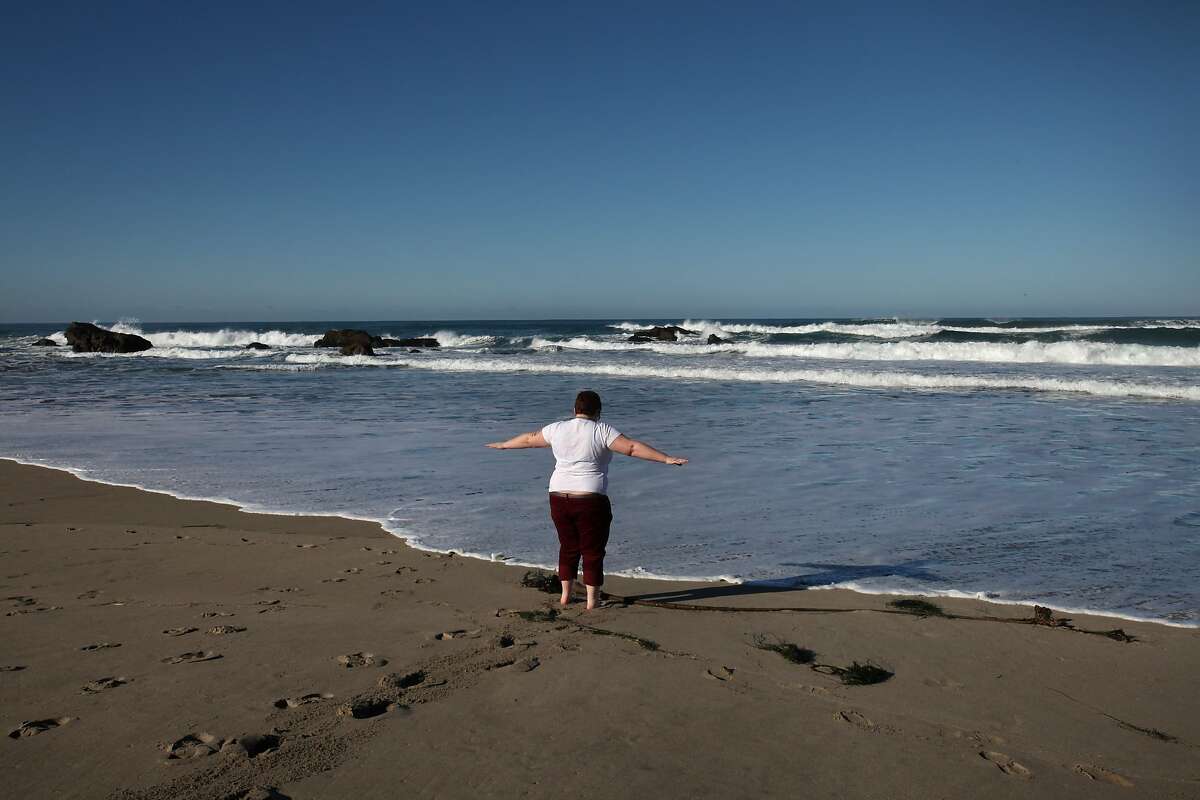 S.E. Smith, 29, allows the ocean to lap their feet at Pudding Creek Beach near Smith's home Feb. 1, 2014 in Fort Bragg. Smith says that after spending a week in the city, they like to visit the beach and dip their toes in the water. Smith identifies as Genderqueer; someone who sees gender as more of a spectrum. Because Smith doesn't identify with either normative genders, Smith is living between genders. Smith works as a freelance writer and editor and recently wrote a young adult fiction book about a transgendered teen that Smith is trying to get published. Smith says it was when they met like-minded individuals in college that they started questioning society's gender-norms. Currently, Smith has a places in both Fort Bragg and Berkeley so they can enjoy city life, as well as life near trees, the ocean and also be near Smith's father.