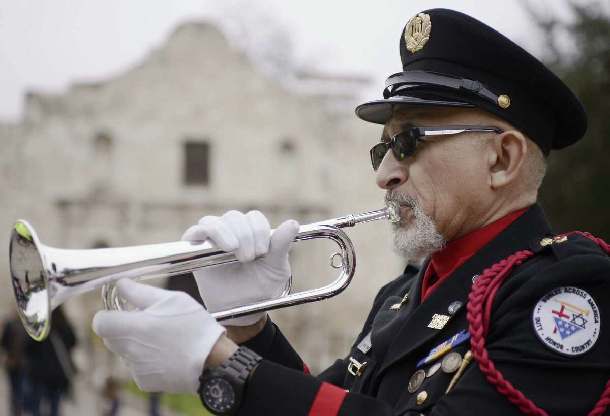 Auston O'Neill of Bugles Across America sounds taps in front of the Alamo during the Keep the Spirit of '45 Alive! touring RV's stop at Alamo Plaza.