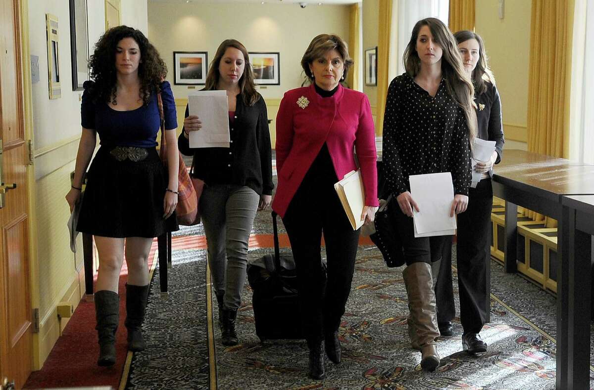 Attorney Gloria Allred, center, walks with University of Connecticut students Rose Richi, left, Erica Daniels, Carolyn Luby, second from right, and Kylie Angell, right, to a news conference in Monday, Oct. 21, 2013, in Hartford, Conn. Four women who say they were victims of sexual assaults while students at the University of Connecticut have announced they are filing a federal discrimination lawsuit against the school.