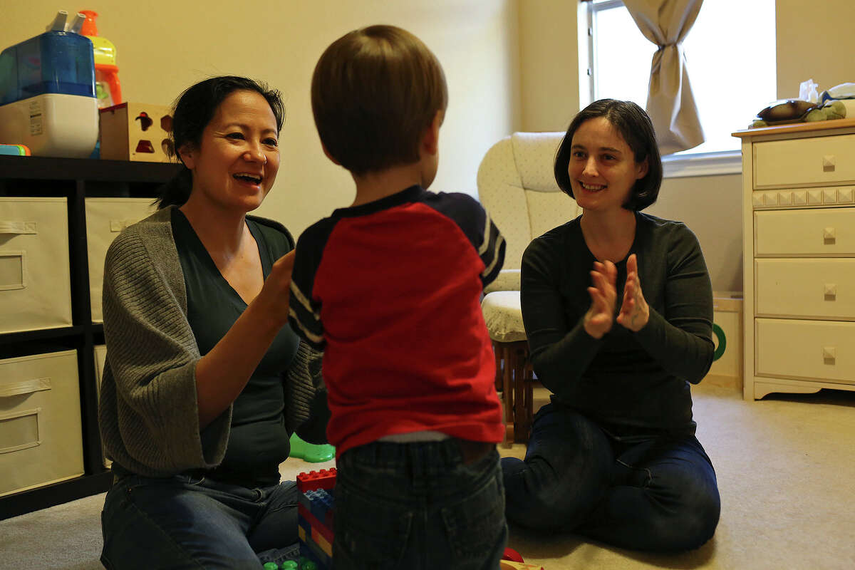 Cleo DeLeon, left, and Nicole Dimetman play with their son at their home in Austin on Saturday, Feb. 8, 2014.