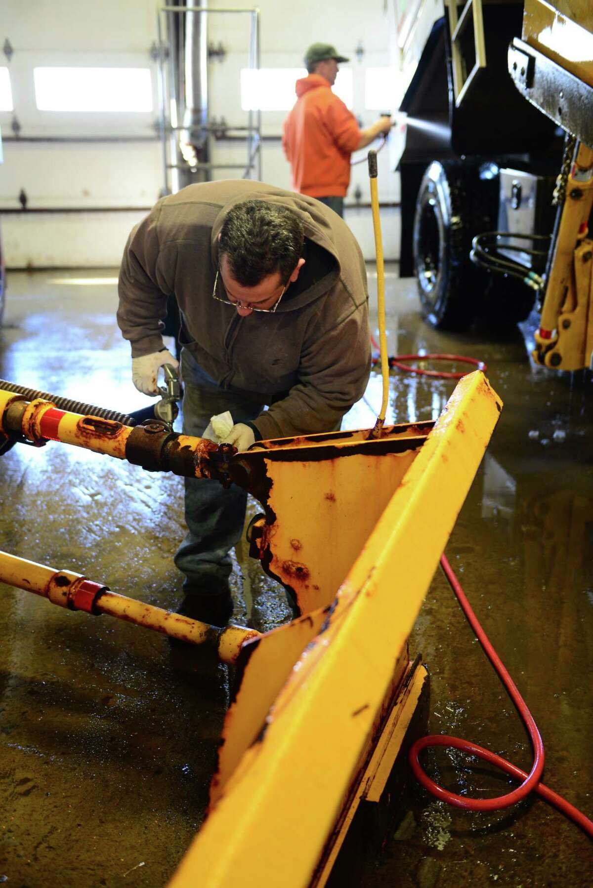New York State Department of Transportation highway maintenance workers Michael Casso, left, and Robert Cocca, right, prepare their snowplows for duty Wednesday afternoon, Feb. 12, 2014, at the state DOT garage on Watervliet Shaker Rd in Colonie, N.Y. DOT crews are getting ready for Thursday's expected snowstorm. The snowplows are put through a weekly maintenance service by the drivers. (Will Waldron/Times Union)