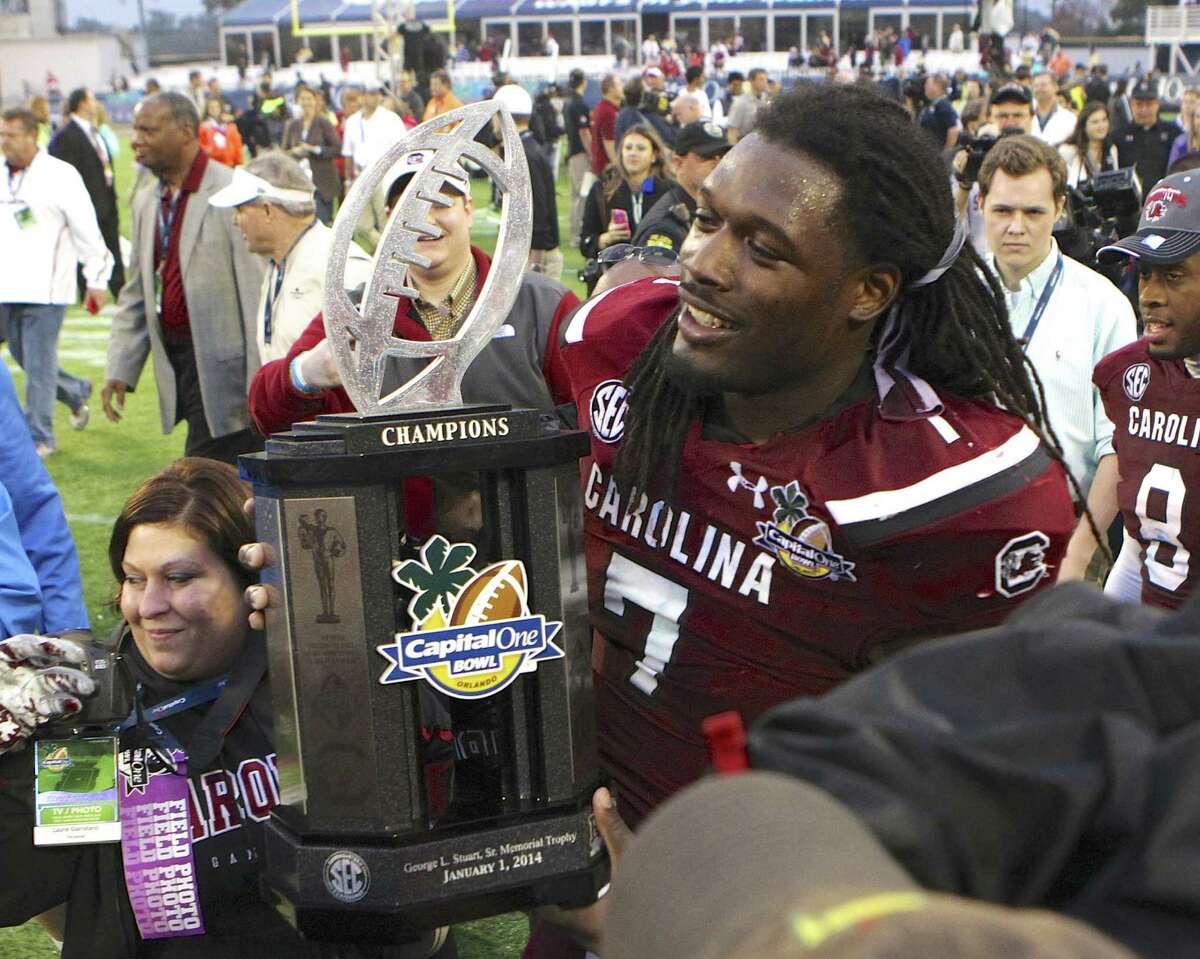 South Carolina defensive end Jadeveon Clowney (7) holds the championship trophy after a 34-24 win against Wisconsin in the Capital One Bowl on Wednesday, Jan. 1, 2014, in Orlando. (Joe Petro/The State/MCT)