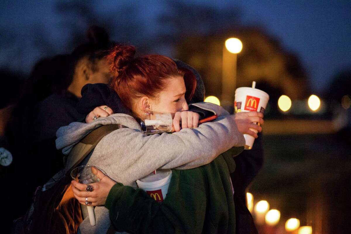 Ashlee Brown, 15, left, and Reagan Deschenes, 18, embrace at a vigil in Clear Lake for Corriann Cervantes. Officers say Cervantes was sexually assaulted and killed by two boys in a satanic ritual on Feb. 5.