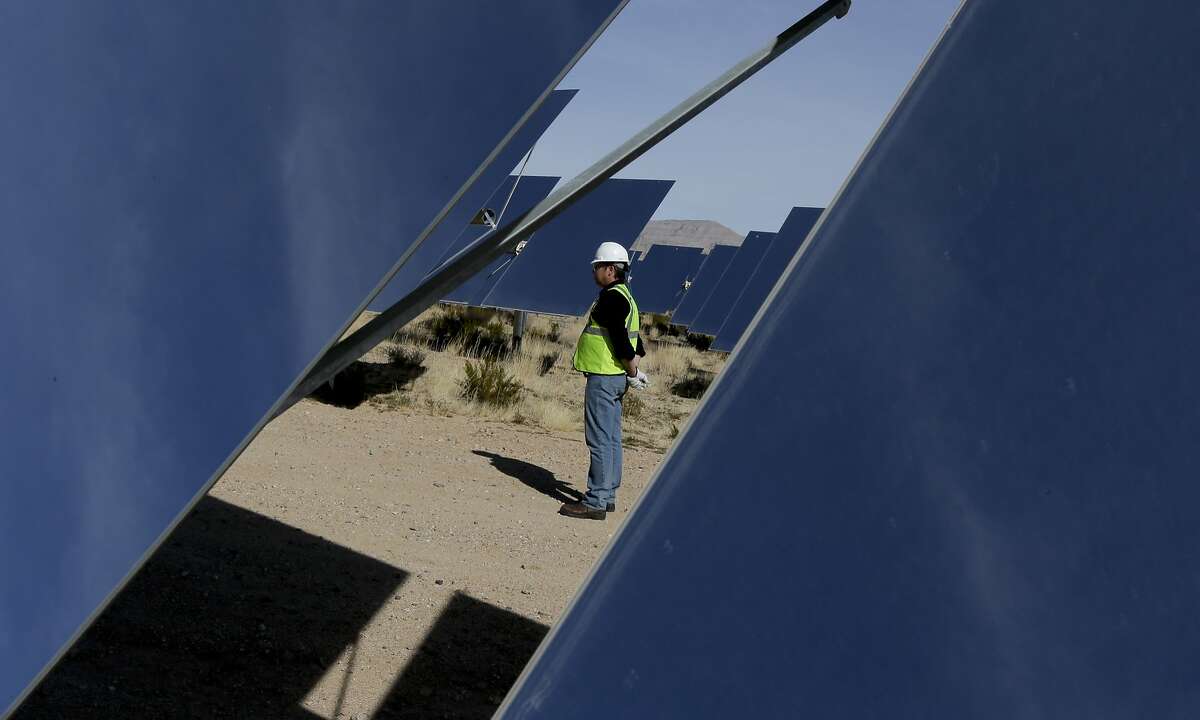 HOLD BY STORY SLUGGED: Solar Power Rising BY MICHAEL R. BLOOD and BRIAN SKOLOFF -- Noel Hanson stands near some of 300,000 computer-controlled mirrors that reflect sunlight to boilers that sit on 459-foot towers near a boilers that sit on 459-foot towers Tuesday, Feb. 11, 2014 in Primm, Nev. The Ivanpah Solar Electric Generating System, sprawling across roughly 5 square miles of federal land near the California-Nevada border, will be opened formally Thursday after years of regulatory and legal tangles. (AP Photo/Chris Carlson)