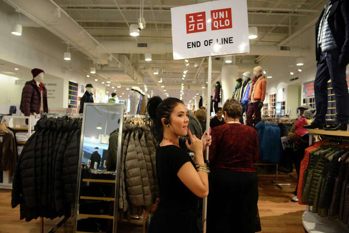 Ashley Bright, of Norwalk, holds up a sign at the end of a growing line of customers waiting to checkout at UNIQLO's new Westfield Trumbull Mall store Friday, Nov. 8, 2013 during their grand opening sale.