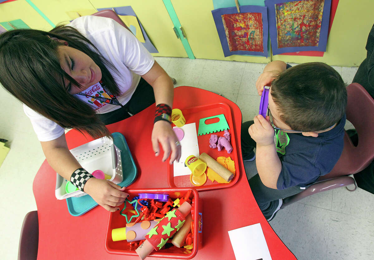 South San student Michaela Valdez tutors five year old Ray Santiago in a prekindergarten class at Kindred Elementary on February 12, 2014.