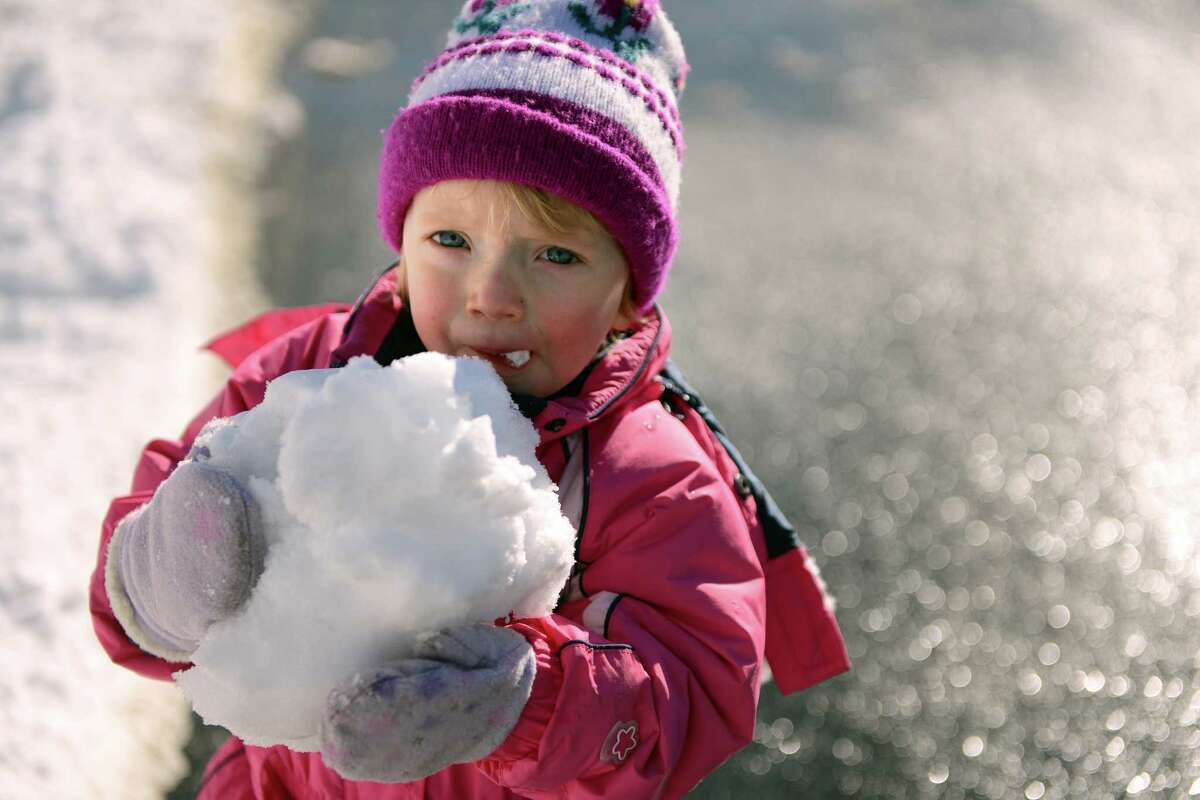 Twenty-one-month-old Rebecca DeMarco samples some snow while out for a walk with her mother in Shelton, Conn. Friday, Feb. 14, 2014.