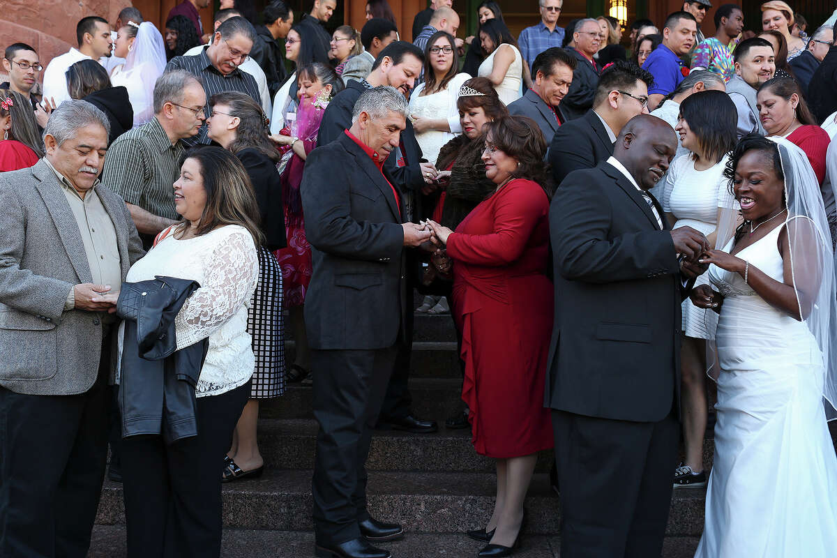 Couples including David and Dianna Flores, who have been married for 33 years and renewed their vows, Edgar and Ernestina Gonzalez, and Lonnie Hines with Erma Prince, get married during a mass wedding on the steps of the Bexar County Courthouse in San Antonio on Friday, Feb. 14, 2014.