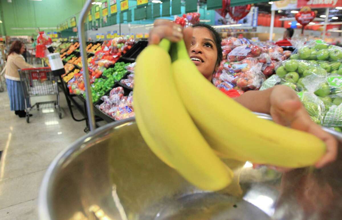 Misha Chishty, University of Houston student, weighs bananas then has to put some back, realizing she can't afford all she wants.