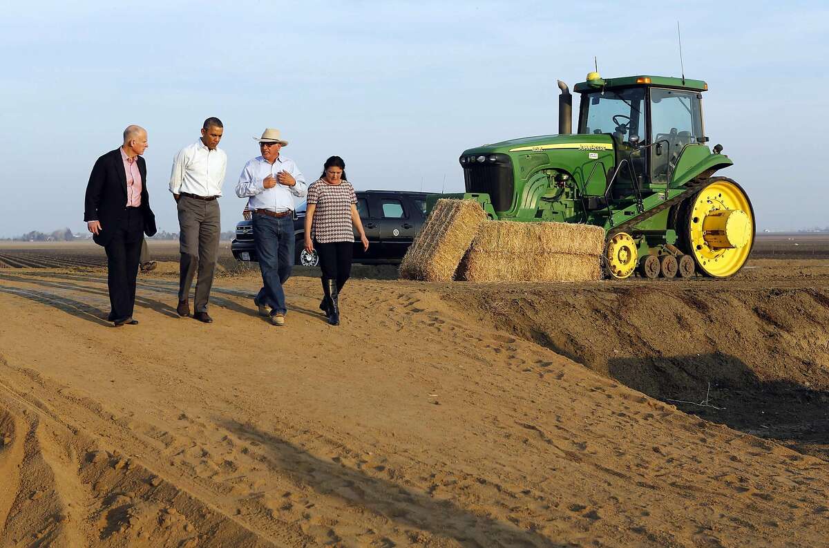 U.S. President Barack Obama walks with farmers Joe Del Bosque and Maria Del Bosque as he tours a drought affected farm field in Los Banos, California February 14, 2014. California Governor Jerry Brown is at left. President Obama will pledge on Friday to speed federal assistance to help California recover from a crippling drought that is threatening the critical agriculture industry in the No. 1 farm state. REUTERS/Kevin Lamarque (UNITED STATES - Tags: POLITICS ENVIRONMENT AGRICULTURE)