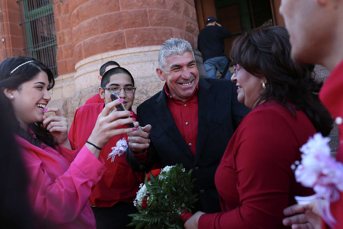Ernestina and Edgar Gonzalez, right, laugh with Edgar's children, Taylor Gonzalez, far left, and Matthew Gonzalez, after they got married in a mass wedding on the steps of the Bexar County Courthouse in San Antonio on Friday, Feb. 14, 2014.