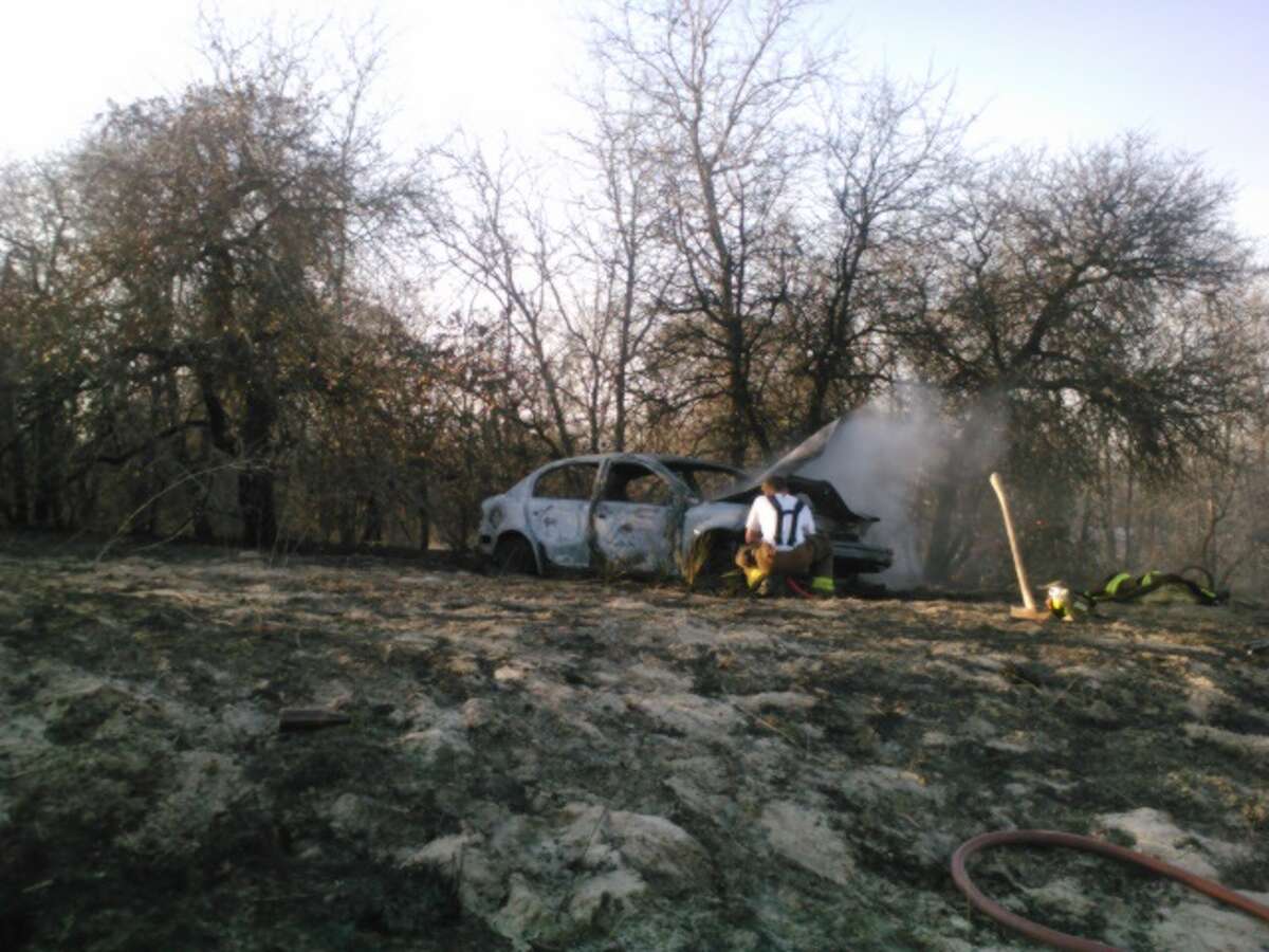 Crews from four area fire departments battled a brush fire Saturday afternoon on the far Southeast Side after a wrecked car burst into flames.