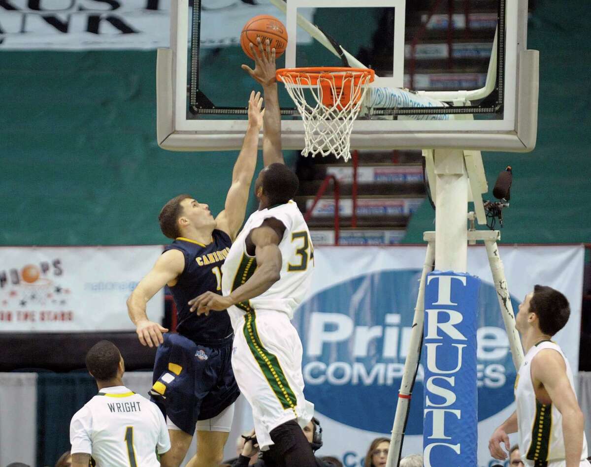 Billy Baron, left, of Canisius has his shot blocked by Imoh Silas of Siena during the Siena and Canisius menOs basketball game at the Times Union Center on Sunday, Feb. 16, 2014 in Albany, NY. Goaltending was called on Silas. (Paul Buckowski / Times Union)