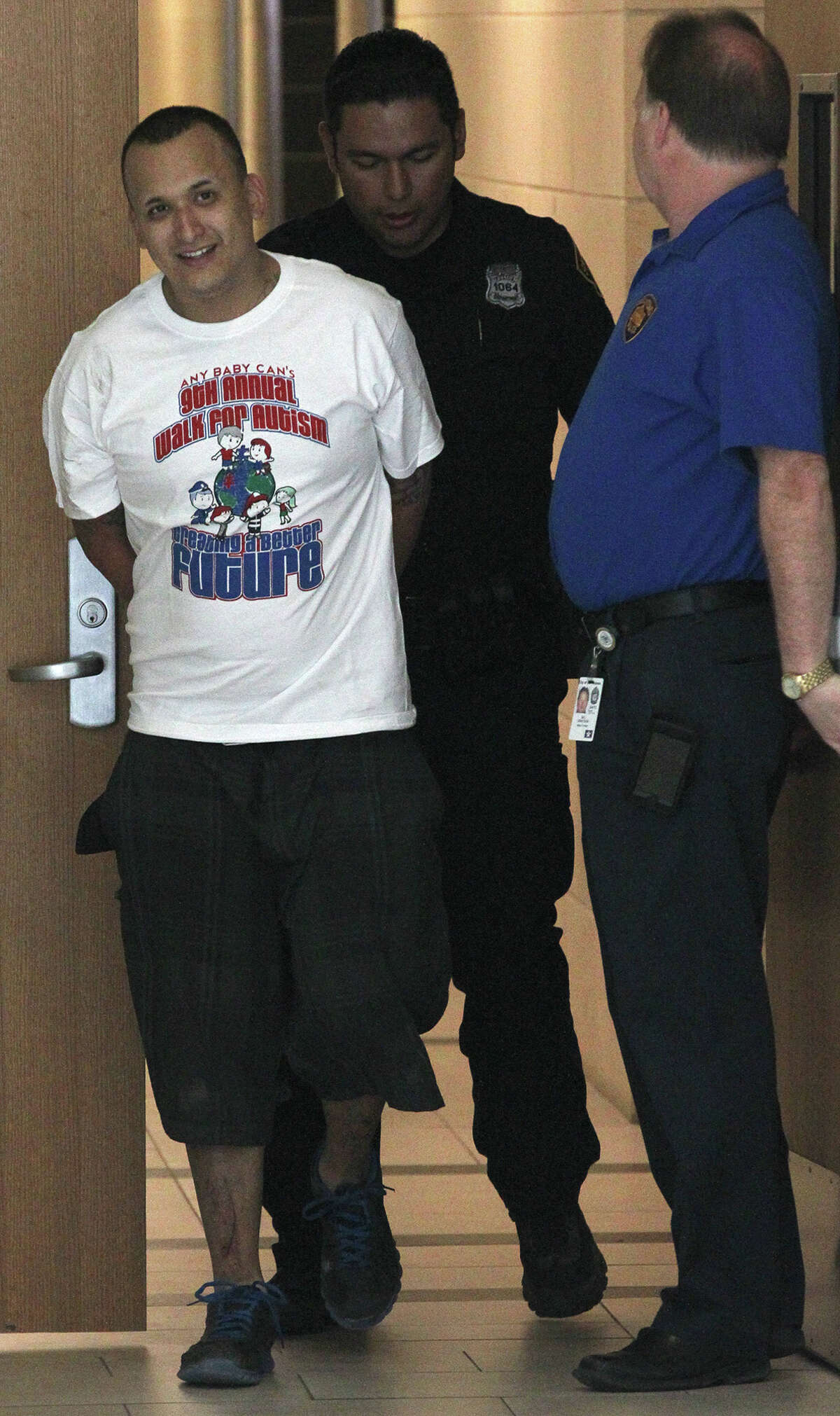 Suspect Nicolas Gutierrez (left) is escorted Monday February 17, 2014 to a police car after being charged with sexual assault of a child, unlawful restraint and kidnapping. Gutierrez and another suspect, Johnny Garcia, allegedly held a 15-year-old girl at a local hotel against her will. Garcia is already in jail.