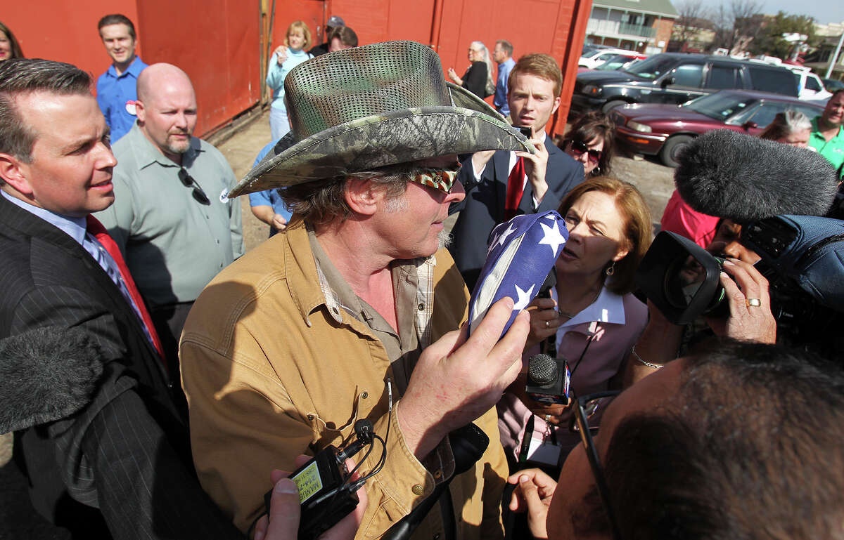 Ted Nugent , holding a flag given to him, is popular in the parking lot after he speaks at a campaign event for Greg Abbott at El Guapo's restaurant in Denton on February 18, 2014.